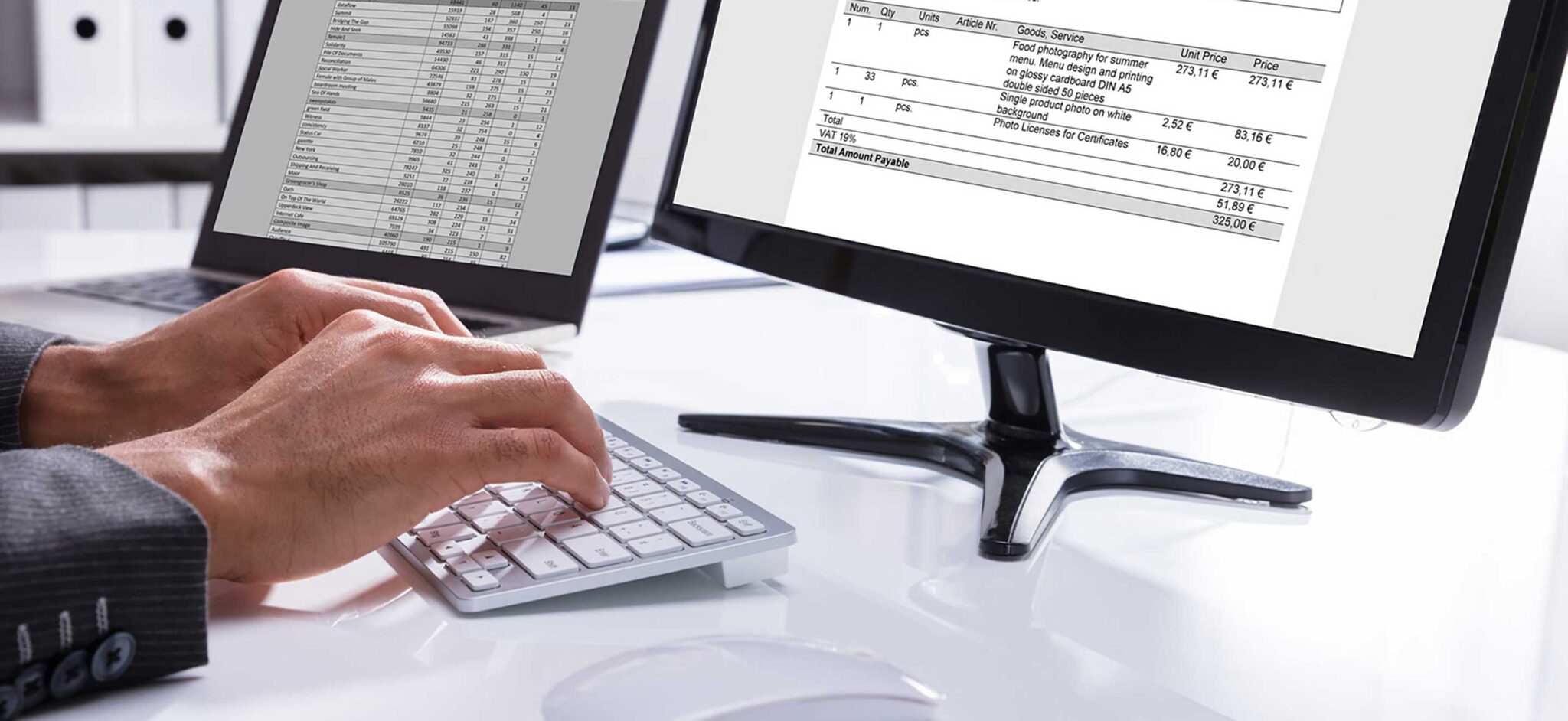 Person typing on a keyboard with an invoice document displayed on a computer monitor.