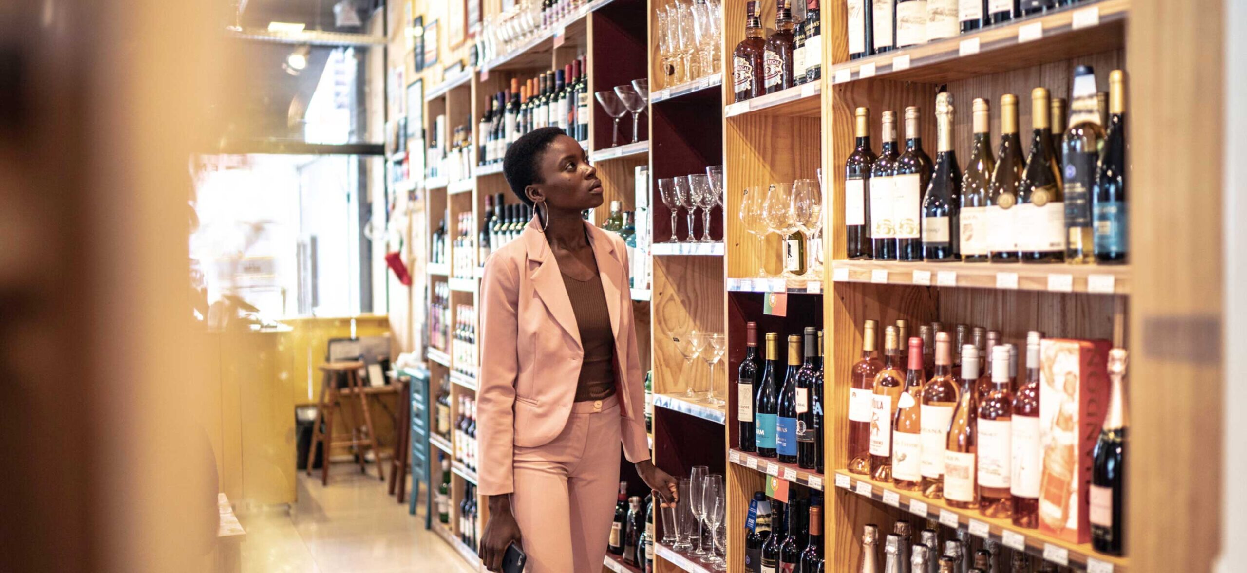 Woman browsing wine selection in a liquor store.