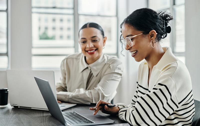 Two women working with laptops